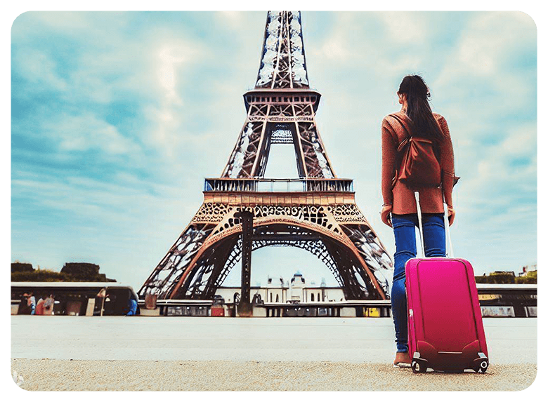 Woman standing in front of Eiffel Tower with suitcase